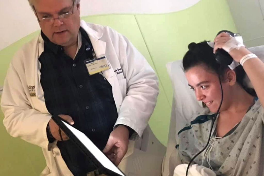 Pediatric Neurologist John Zempel, MD, PhD, shows Emma how to monitor her own brain activity using the NeuroPace device.